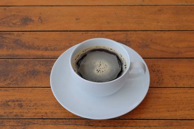 Tahta bir masanın üzerinde bir fincan sade kahve. Beyaz seramik bardak. Yiyecek ve içecek konsepti. Grafik tasarımı için, 3B görüntüleme ve pankart arkaplanı