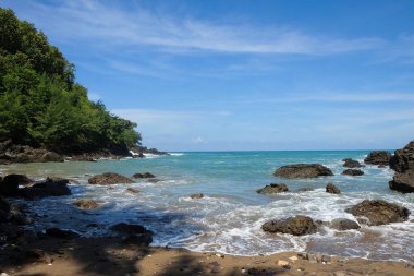 Yeşil kayalıkları olan güzel bir sahil manzarası. Yaz tatili kavramı. Grafik tasarımı, pankart arkaplanı ve 3B oluşturma için
