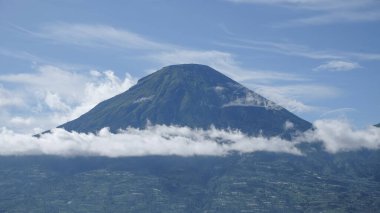 Mavi gökyüzü gününde bulutlu dağ manzarası. Endonezya 'nın Sindoro Dağı zirvesi. Grafik tasarımı, pankart arkaplanı ve 3B oluşturma için