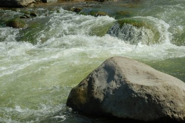 Berrak bir dağ nehrinin kenarındaki büyük kayaların görüntüsü. Reklam ürünü yerleştirme ihtiyaçları için. Grafik tasarımı, afiş arkaplanları ve 3D canlandırma için