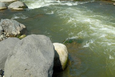 Berrak bir dağ nehrinin kenarındaki büyük kayaların görüntüsü. Reklam ürünü yerleştirme ihtiyaçları için. Grafik tasarımı, afiş arkaplanları ve 3D canlandırma için