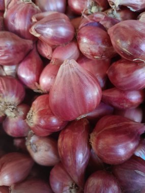 Arka plan ve doku olarak taze ve mis kokulu soğan yığınları veya kırmızı soğan