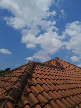 Çatı kiremitleri, mavi gökyüzü arkaplanı ve beyaz bulutlar, kopyalama alanı ile evin çatısı.