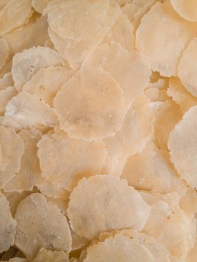 Çiğ emzirme melinjo çıtır cipsi veya kraker yığını, kızartılmaya ve servis edilmeye hazır tipik bir Endonezya atıştırmalığı, arka plan ve doku için tam çerçeve çekimi.