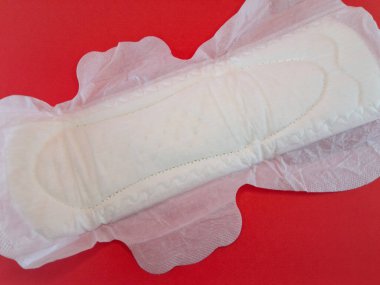 Pamuktan ve diğer doğal malzemelerden yapılmış kan emici pedlerle tek kullanımlık pedler ya da peçeteler, kırmızı arka planda izole edilmiş kadınlık ve kadın mahrem organları için hijyen kavramı..