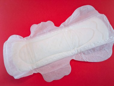 Pamuktan ve diğer doğal malzemelerden yapılmış kan emici pedlerle tek kullanımlık pedler ya da peçeteler, kırmızı arka planda izole edilmiş kadınlık ve kadın mahrem organları için hijyen kavramı..