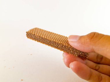 Her katmanda çikolatalı süt karışımı olan çıtır çıtır gofret çubuk çubuğu her ısırıkta çıtır çıtır bir izlenim verir, beyaz bir arkaplanda izole edilmiş ve yakın çekim.