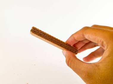 Her katmanda çikolatalı süt karışımı olan çıtır çıtır gofret çubuk çubuğu her ısırıkta çıtır çıtır bir izlenim verir, beyaz bir arkaplanda izole edilmiş ve yakın çekim.