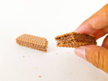 Her katmanda çikolatalı süt karışımı olan çıtır çıtır gofret çubuk çubuğu her ısırıkta çıtır çıtır bir izlenim verir, beyaz bir arkaplanda izole edilmiş ve yakın çekim.