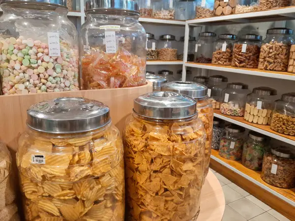 Jakarta, Endonezya - 16 Mart 2024: tuzlu atıştırmalıklar, parti karışımı. Patates cipsi ve tortilla, kraker ve diğer aperatifler kiloyla satılıyor, sağlıksız bir yeme konsepti..