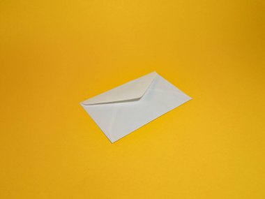 Sarı arka planda sade beyaz zarf, katlanmış zarf tasarım ögesi yazışmalar, iş yerleri, doğum günleri ve davetiyeler için..