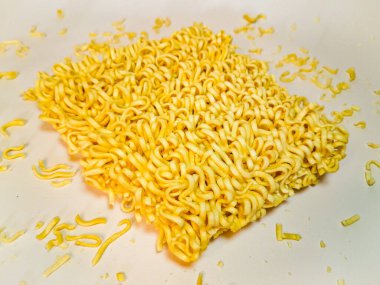 Dağınık kırıntılı pişmemiş sarı hazır şehriye, kurutulmuş Ramen Eriştesi, Çiğ Kore Vermicelli, Fast Food Çin Makarnası. Görüntüyü kapat ve beyaz arkaplanda izole et.