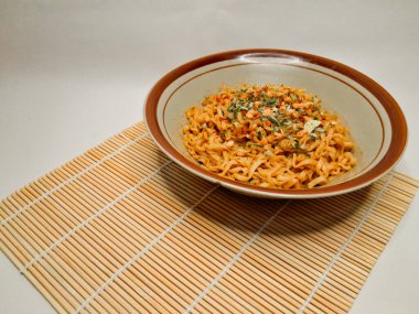 Üzerine kurutulmuş sebze ve baharat serpiştirilmiş, beyaz arka planda izole edilmiş ve yakın plan çekimleri yapılan basit bir Hindistanlı hazır şehriye kasesi..