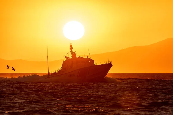 在夕阳西下 警船在背景明媚的阳光下快速地穿过海湾 — 图库照片