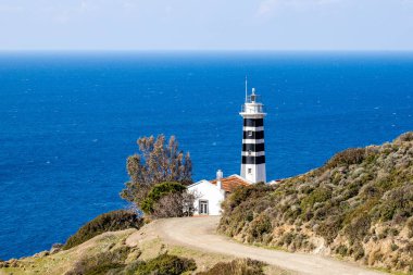 Yol manzarası mavi denizin arka planındaki deniz fenerine gider.