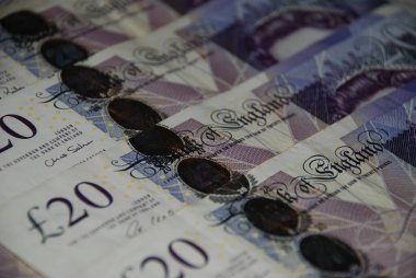 Üst üste dizilmiş 20 poundluk İngiliz banknotlarını gösteren detaylı bir yakın çekim. Görüntü, zenginlik ve finansı sembolize ederek, İngiltere para biriminin dokusunu, detaylarını ve tasarımını vurgular..