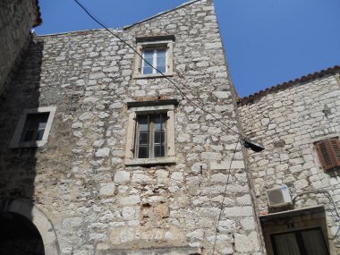 Tarihi mimarisini sergileyen yıpranmış taş bir bina eski bir kasabada dimdik ayakta duruyor..