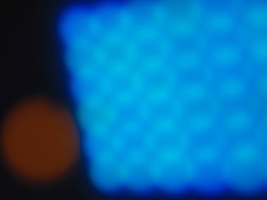 A blurred background with varying shades of orange and blue, creating a bokeh effect with light spots. Ideal for use as a backdrop in design projects or as a texture in visual art. clipart