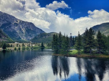 Kıyı boyunca dağlarla çevrili dağlarla çevrili bir orman.