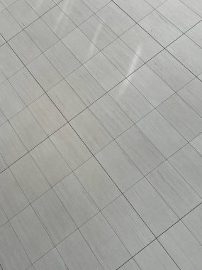 Geniş fayanslı zemin güneş ışığıyla geniş açık lobide.