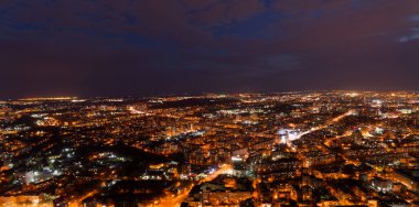 Geceleri ışıklar açıkken şehir. Şehir aydınlandı ve gökyüzü bulutlu.