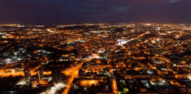 Geceleri ışıklar açıkken şehir. Şehir aydınlık ve gökyüzü karanlık.