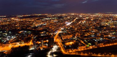 Geceleri ışıklar açıkken şehir. Şehir aydınlandı ve gökyüzü bulutlu.
