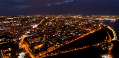 Geceleri ışıklar açıkken şehir. Şehir aydınlandı ve gökyüzü bulutlu.