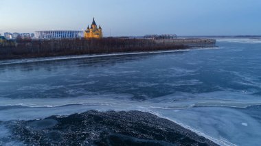 Arka planda kilise olan donmuş bir göl. Gökyüzü mavi ve mor karışımı.