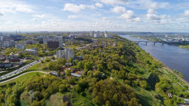 İçinden nehir akan bir şehir. Şehir binalar ve ağaçlarla dolu. Gökyüzü bulutlu.