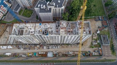 Arkasında vinç olan bir inşaat alanı. Vinç sarı ve sahnenin ortasında.