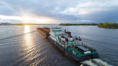 Büyük gemi, arka planda güneş batarken, suda ilerliyor. Sakinlik ve sükunet kavramı