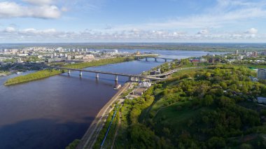 Üzerinden nehir akan ve üzerinde köprü olan bir şehir. Köprü büyüktür ve nehir boyunca uzanır. Şehir hareketli ve hareketli bir atmosfere sahip.