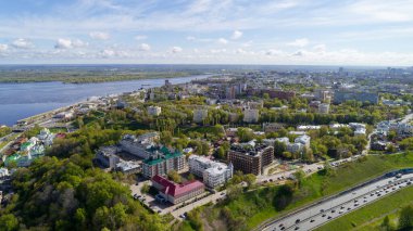 İçinden nehir akan bir şehir. Binalar yüksek ve yolda bir sürü araba var.
