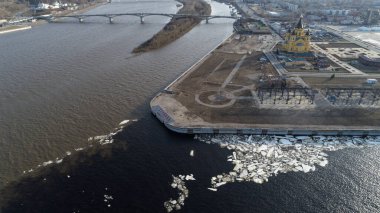 İçinden nehir akan bir şehir. Su kahverengi ve bulanık. Şehir nehrin sağ tarafında.