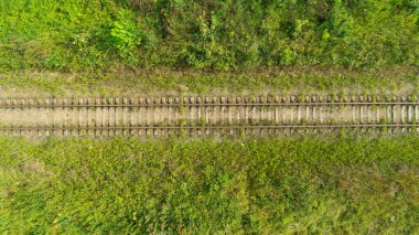Tren yolu yeşil bir alanda gösterilir. Tren yolu boş ve çimenler yemyeşil.