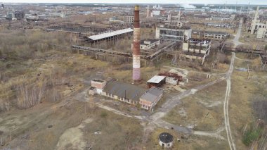 Issız, terk edilmiş, merkezinde büyük tuğla bir bina olan bir şehir. Bina büyük boş bir arsayla çevrilidir.