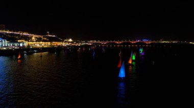 Bir grup renkli yelkenli gece gökyüzünde yelken açıyor. Tekneler neon ışıklarıyla aydınlanıyor, neşeli ve canlı bir atmosfer yaratıyorlar. Sahne güzelliği yakalar. - Evet. Nizhny Novgorod