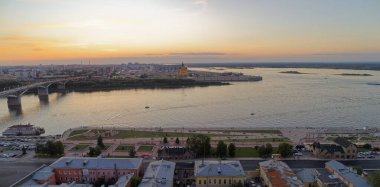 City skyline with a large body of water in the background. The sky is orange and the water is calm. Nizhny Novgorod clipart