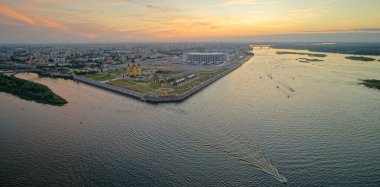 İçinden nehir akan bir şehir. Su sakin ve gökyüzü turuncu. Şehir geceleri aydınlık oluyor. Nizhny Novgorod