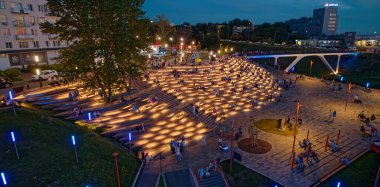 Bir grup insan gece bir parkta toplanıyor ve yerde mumlar yanıyor. İnsanlar oturup mumların sıcak parıltısının tadını çıkarırken atmosfer huzurlu ve huzurlu. Nizhny Novgorod