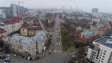 Trafik ve yüksek binalarla dolu bir şehir caddesi. Gökyüzü bulutlu ve şehir geçiş halindeymiş gibi görünüyor. Nizhny Novgorod