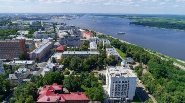 Şehir manzarası ve içinden bir nehir geçiyor. Binalar yüksek ve gökyüzü mavi. Nizhny Novgorod