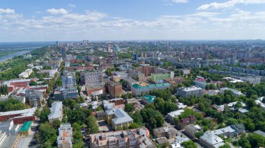 Şehir manzarası bir sürü bina ve ağaçla dolu. Gökyüzü mavi ve bulutlar var. Şehir hareketlilikle dolup taşıyor. Nizhny Novgorod