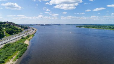 İçinden nehir akan bir şehir. Su bulanık ve gökyüzü bulutlu. Suda bir sürü tekne var. Nizhny Novgorod