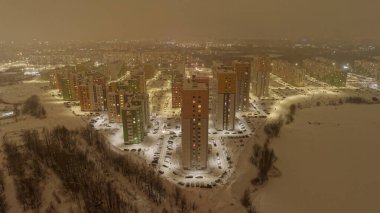 Bir sürü bina ve arabalı şehir manzarası. Gökyüzü karanlık ve binalar aydınlık. Nizhny Novgorod. Burnakovka küçük bölgesi.