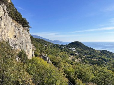 Ormanı ve uzak bir kasabası olan bir dağ. Gökyüzü açık ve mavi