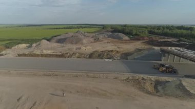 Bir yol manzarası ve ormandaki büyük bir toprak yığını.