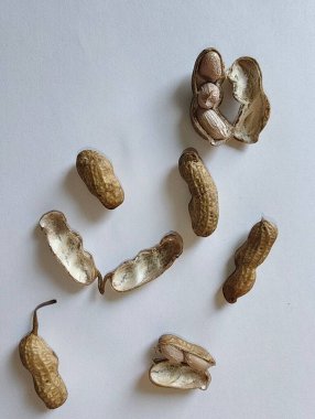 Beyaz arka planda kalp şeklinde kurumuş fıstıklara yakından bak.