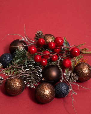 Ağaç dallar ve yeni yıl oyuncakları üzerinde koni ve kırmızı böğürtlen